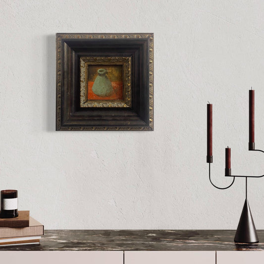 Small framed still life oil painting styled above a modern console table with candles and minimalist interior decor.