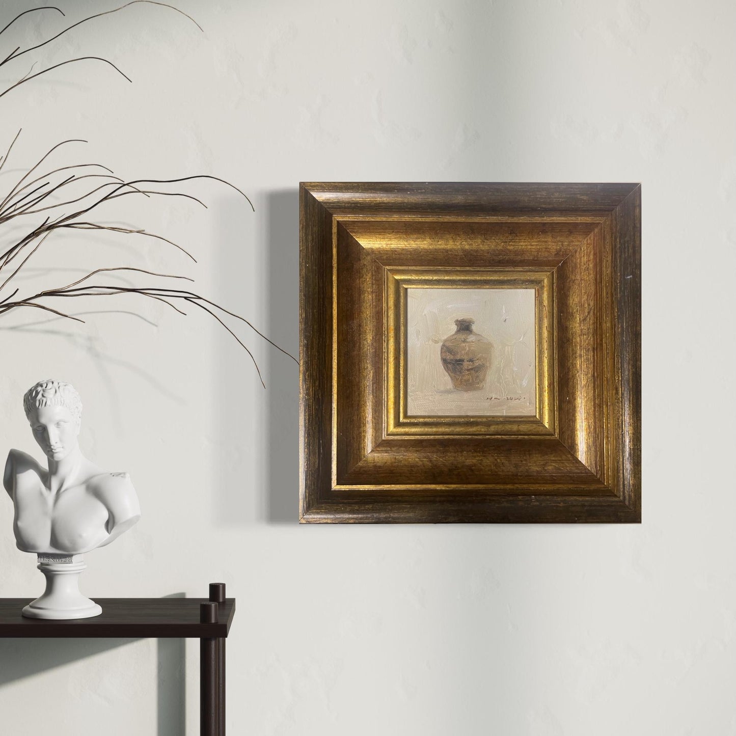 Original still life painting of a ceramic vessel in an antique-inspired gold frame, displayed on a soft neutral wall with natural interior styling.
