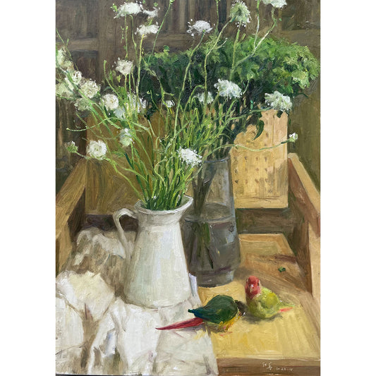 Close-up detail showing white wildflowers arranged beside stacked books, highlighting soft light, texture, and balanced composition.