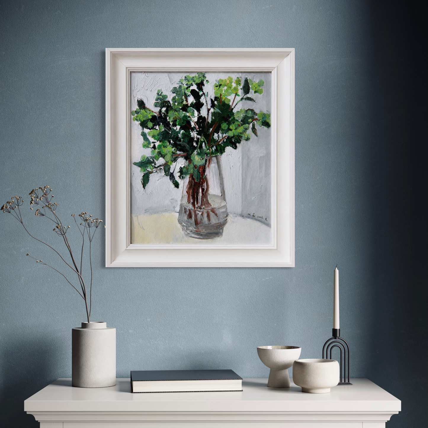 Original greenery still life oil painting styled against a blue-grey wall in a modern interior with calm decorative accents.