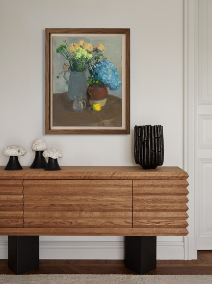 Framed oil painting featuring blue hydrangea and yellow roses displayed in a contemporary interior, creating a sophisticated floral focal point.