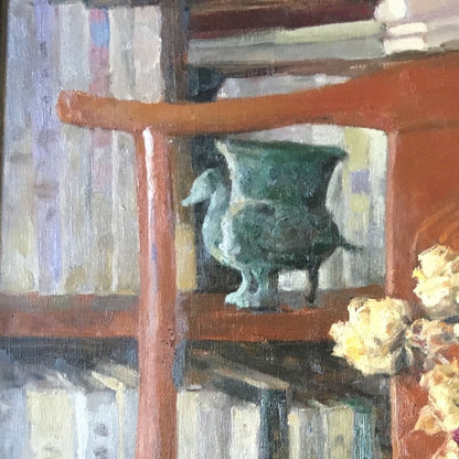 Detail of a bookshelf, ceramic vessel, and wooden interior objects, emphasizing depth, texture, and the quiet character of the study space.