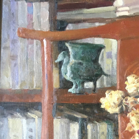 Detail of a bookshelf, ceramic vessel, and wooden interior objects, emphasizing depth, texture, and the quiet character of the study space.