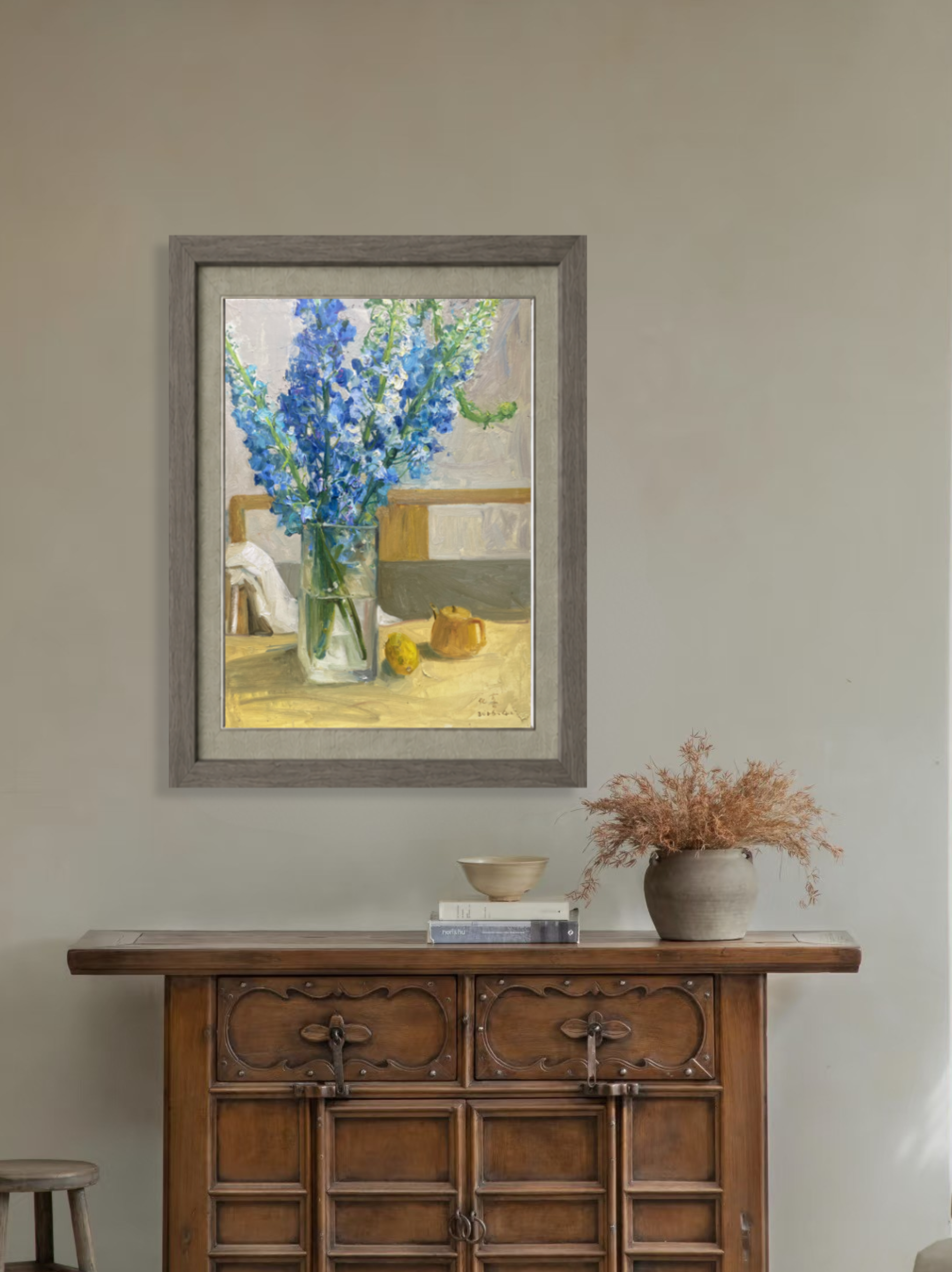 Original floral still life oil painting displayed above a wooden cabinet, bringing freshness, color, and elegance to the interior space.