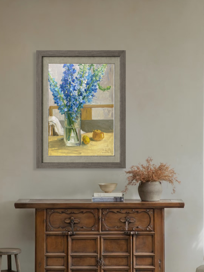 Original floral still life oil painting displayed above a wooden cabinet, bringing freshness, color, and elegance to the interior space.