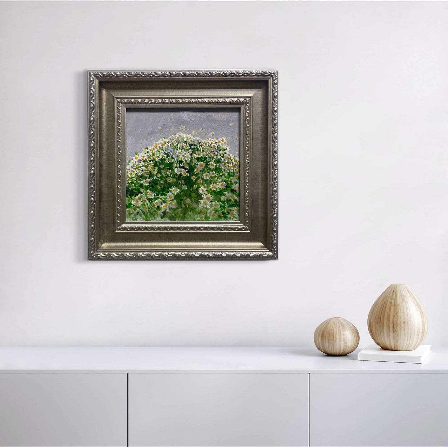 A framed floral oil painting displayed in a minimalist white interior with sculptural ceramic decor, creating a soft and refined gallery-style atmosphere.