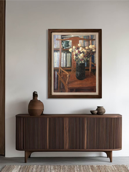 Framed original still life oil painting displayed above a wooden cabinet, bringing warm brown tones and a refined study-room feeling to the interior.