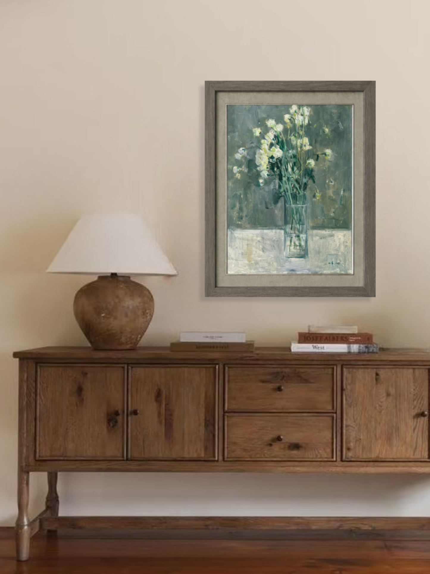 Original floral still life painting displayed above a wooden sideboard, creating a calm focal point in a warm and understated interior.