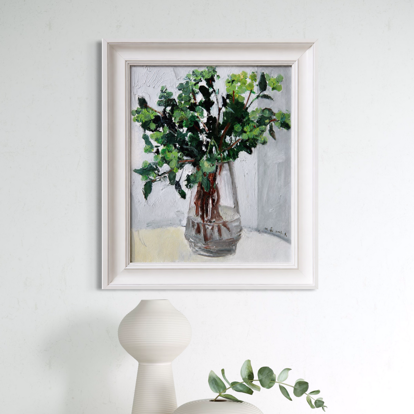 Original greenery still life oil painting framed in soft ivory wood and styled in a calm minimalist interior with sculptural ceramic decor.