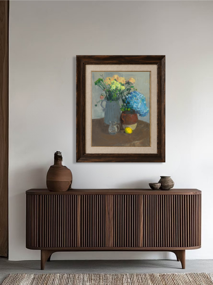Original floral still life painting displayed above a wooden sideboard, adding color, elegance, and artistic character to the interior.