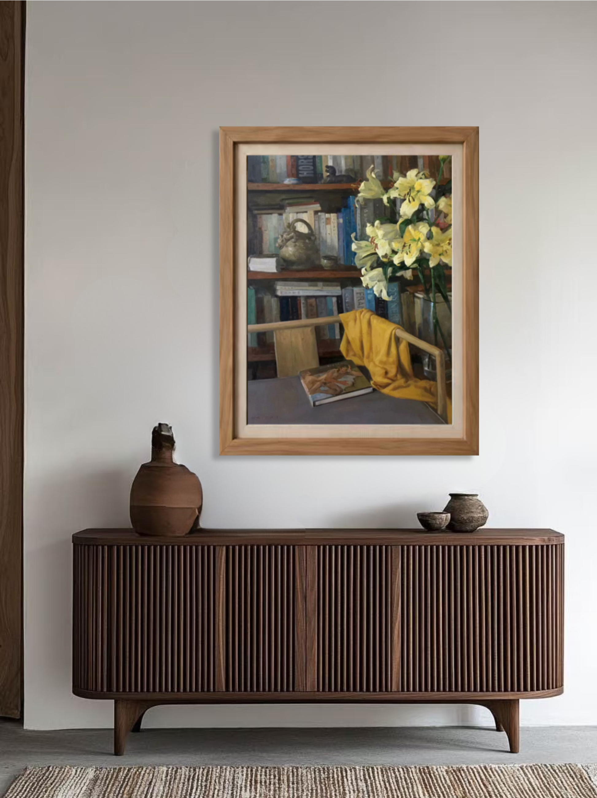 Original oil painting featuring yellow lilies, books, and ceramic vessel displayed on a wooden console, adding warmth and charm to a contemporary interior.