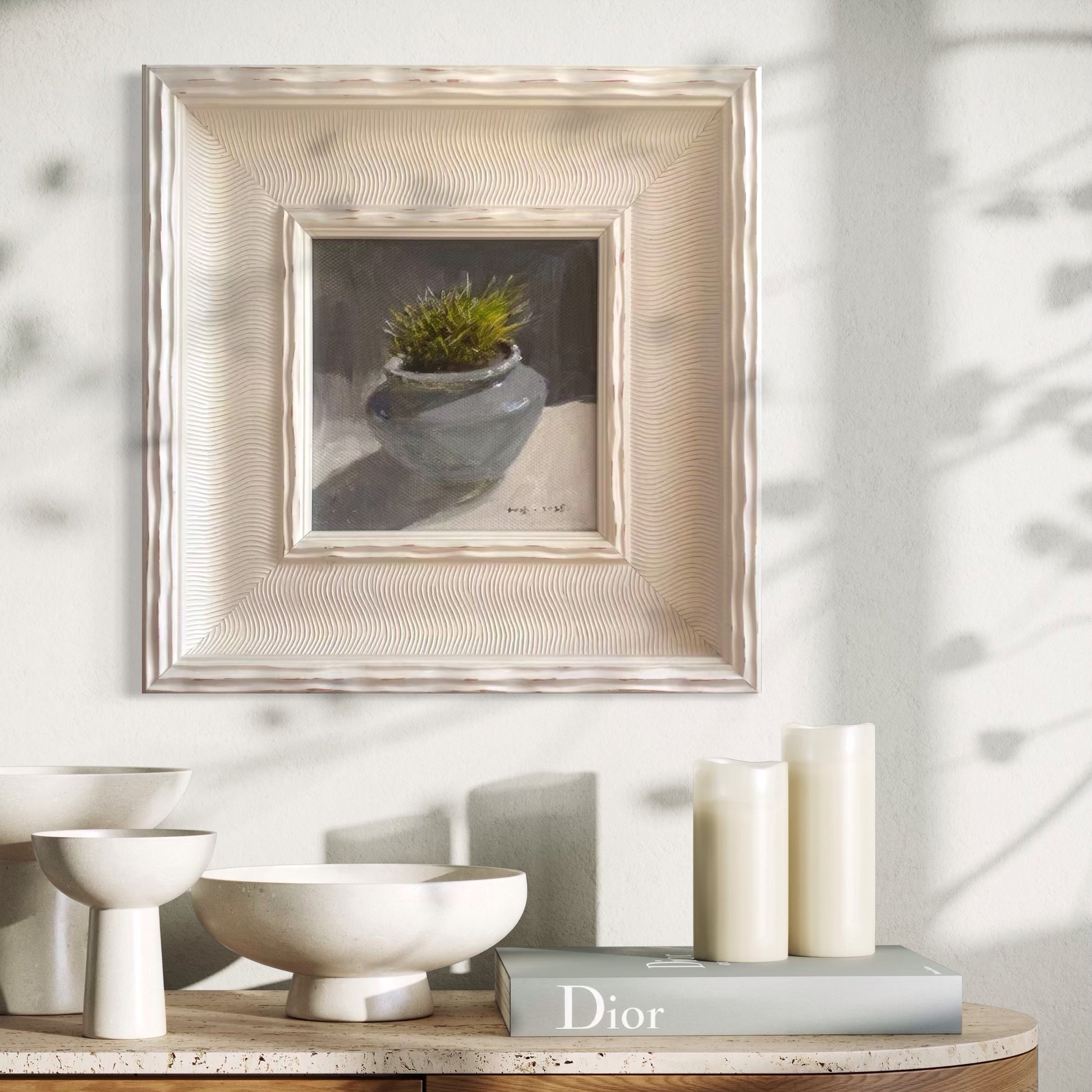A framed original succulent oil painting styled within a calm neutral interior featuring books, ceramics, and soft natural light. The painting adds subtle texture and quiet presence to the modern living space.
