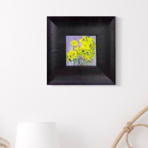 Small framed yellow floral oil painting displayed in a calm minimalist interior with soft neutral tones and modern decor.