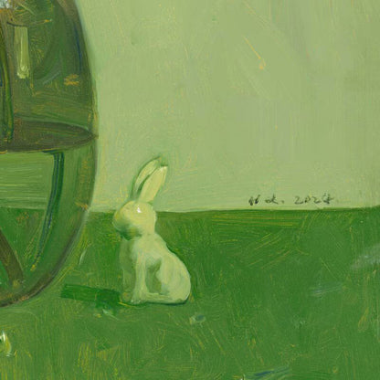 Detail of the green glass vase with white flowers and small decorative rabbit, showing reflections, texture, and quiet still life arrangement.