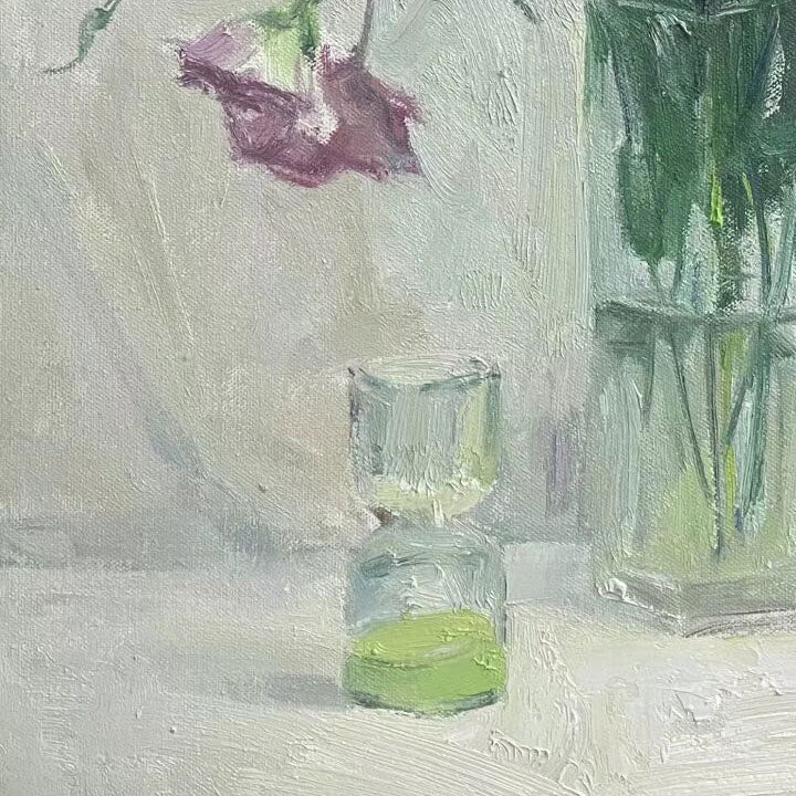 Close-up of a green glass vase and transparent glass vessel, emphasizing reflections, transparency, and the quiet balance of the composition.