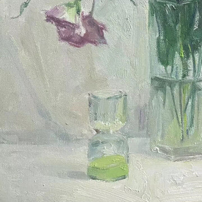 Close-up of a green glass vase and transparent glass vessel, emphasizing reflections, transparency, and the quiet balance of the composition.