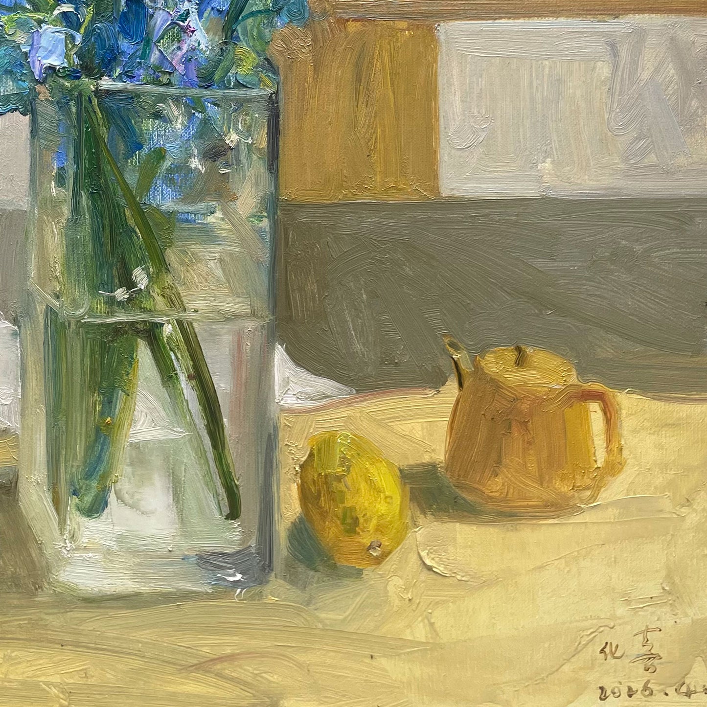 Detailed view of a glass vase holding blue flowers beside fresh lemons, emphasizing transparency, light reflection, and color contrast.