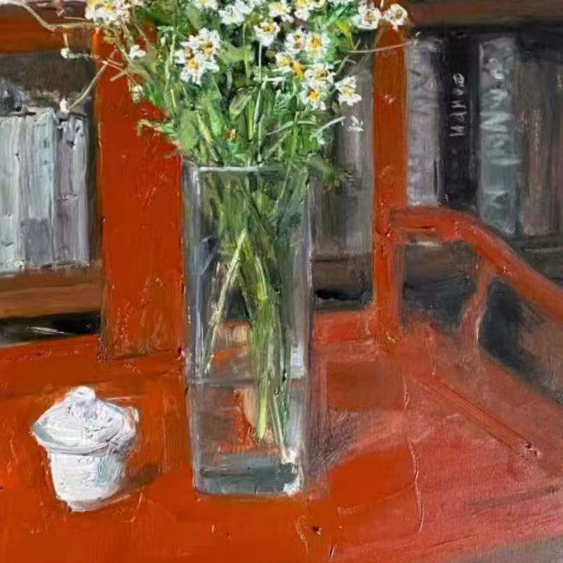 Detailed view of the clear glass vase standing on a red tabletop, highlighting reflections, transparent texture, and the strong color relationship of the composition.
