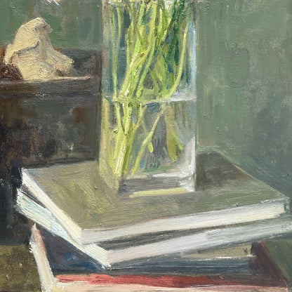 Close-up of the glass vase atop stacked books, emphasizing transparency, reflections, and balance of the still life composition.