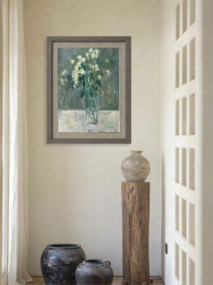 Framed original oil painting featuring green flowers displayed in a minimalist interior, adding softness, depth, and quiet visual presence to the room.