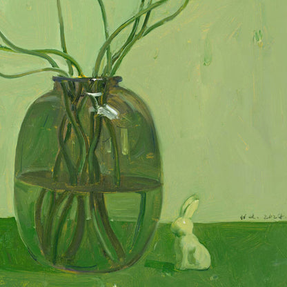 Close-up of a green glass vase filled with flowers beside a small rabbit figurine, emphasizing transparency, reflection, and quiet visual storytelling.