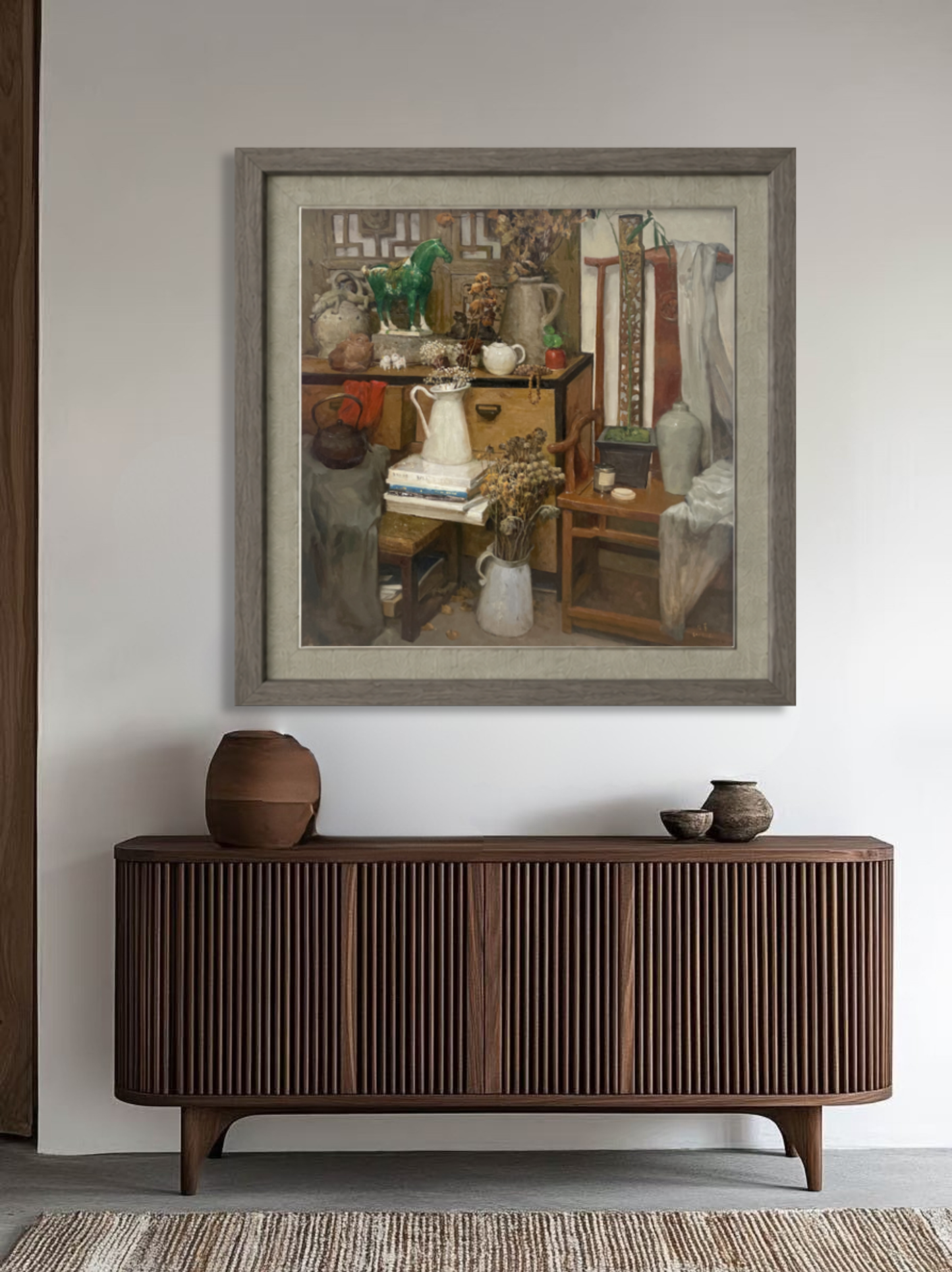 Framed original oil painting featuring collected objects and interior furnishings displayed above a wooden sideboard, creating a refined focal point for the room.