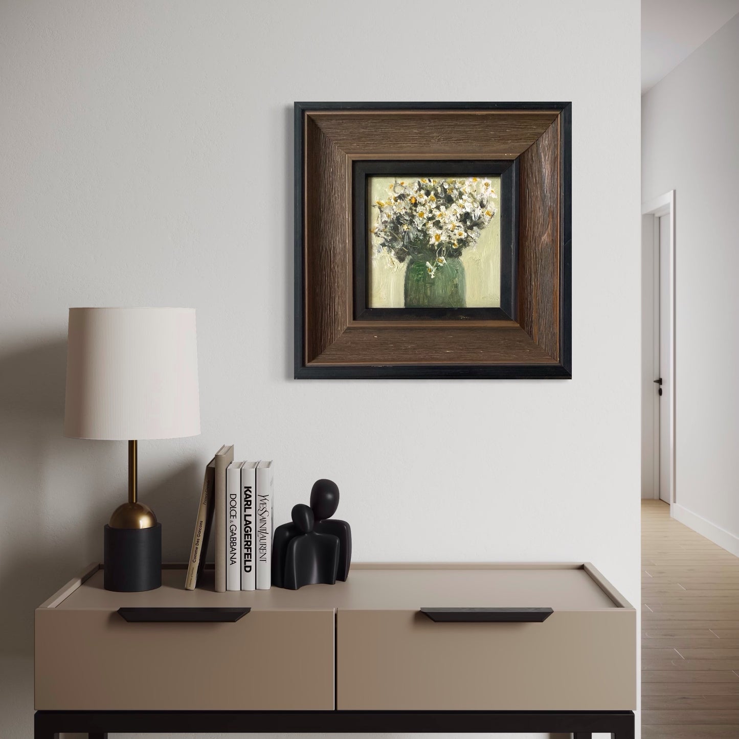 Framed daisy oil painting styled above a minimalist cabinet with modern decorative objects in a calm interior setting.