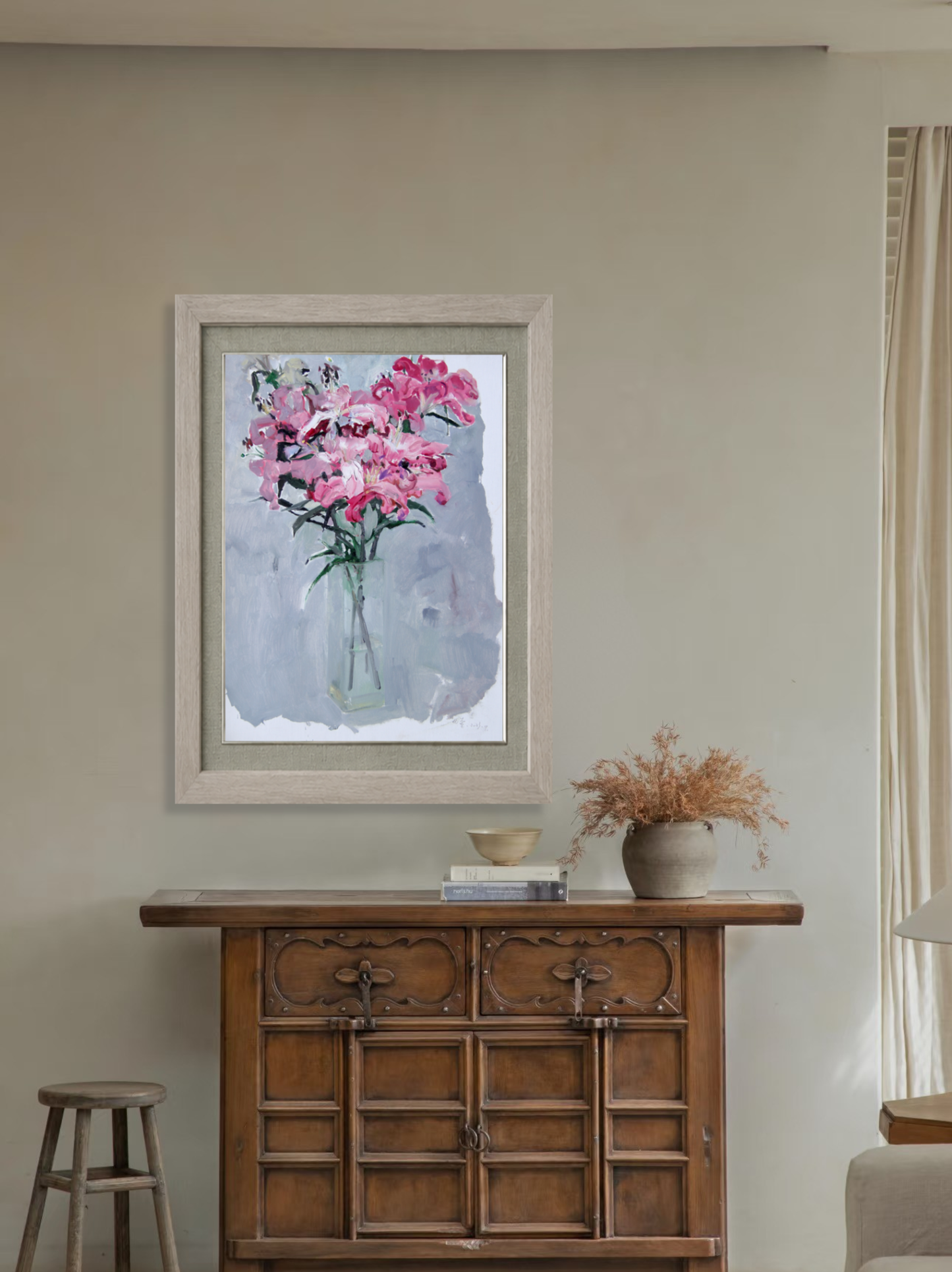 Framed floral artwork displayed above a wooden cabinet, creating a warm and elegant focal point within a minimalist living space.