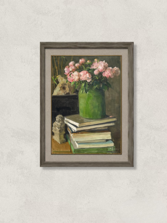 Framed original still life oil painting showing pink flowers in a green vase on top of stacked books, with a small sculpture nearby. A calm, refined composition suitable for interior decor.