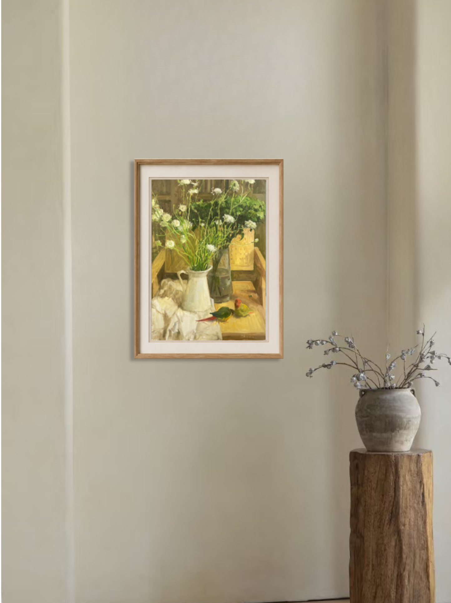 Framed still life artwork featuring flowers, books, and a parrot displayed in a refined interior space with warm and inviting atmosphere.