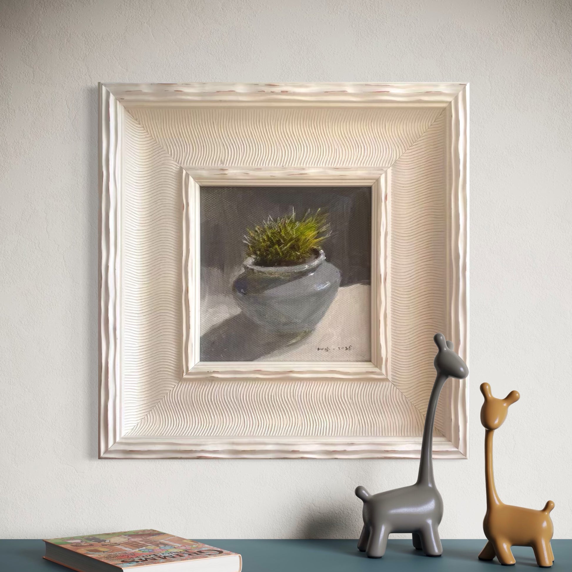 A small framed botanical oil painting displayed in a minimalist contemporary room with soft beige walls and sculptural decor, creating a refined gallery-style atmosphere
