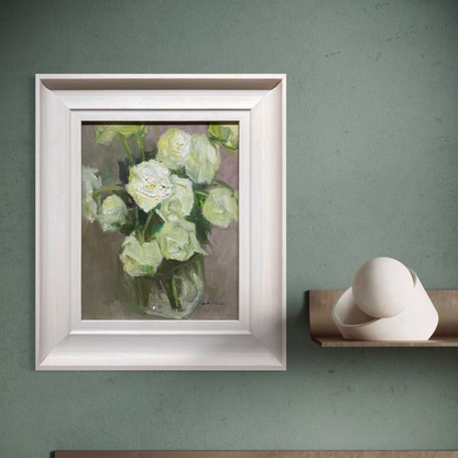 Framed floral oil painting shown in a green-toned interior setting. The layered brushwork and muted palette create a peaceful and collected atmosphere.