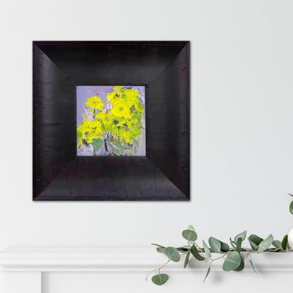 Close-up angled view of a framed yellow floral oil painting, showing the texture of the brushwork and the depth of the black wooden frame.