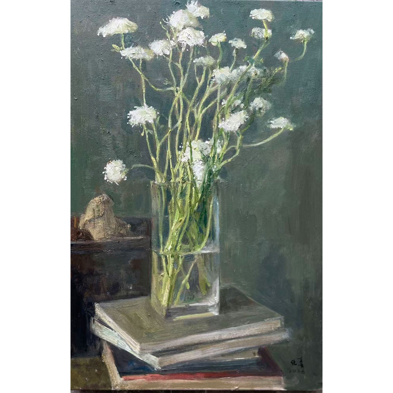 Detail showing white flowers, stacked books, and small decorative objects, revealing layered composition and calm interior atmosphere.