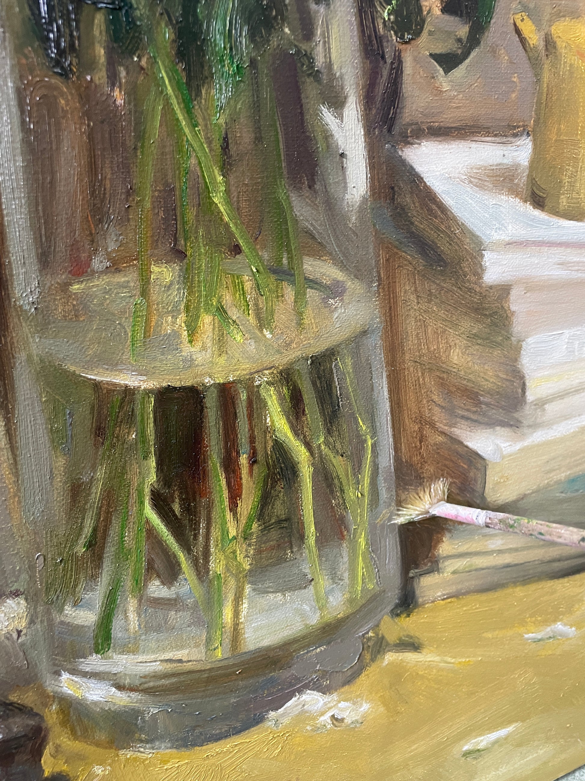 Close-up detail of a transparent glass vase with flower stems, highlighting light and texture.